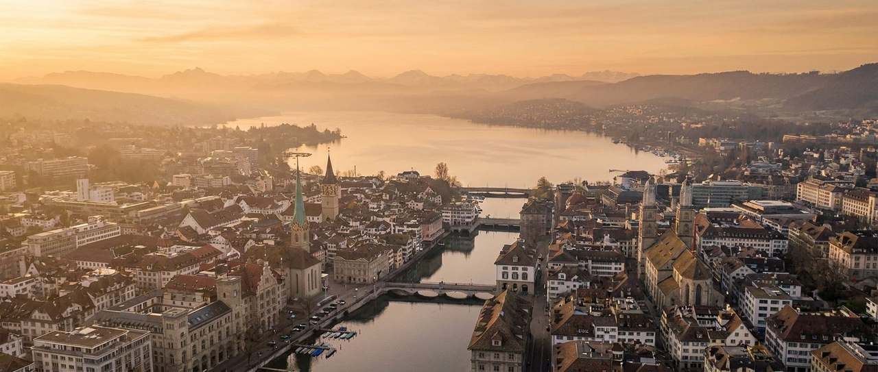 Luftaufnahme von Zürich mit Limmat, Zürichsee und Alpen im Abendlicht
